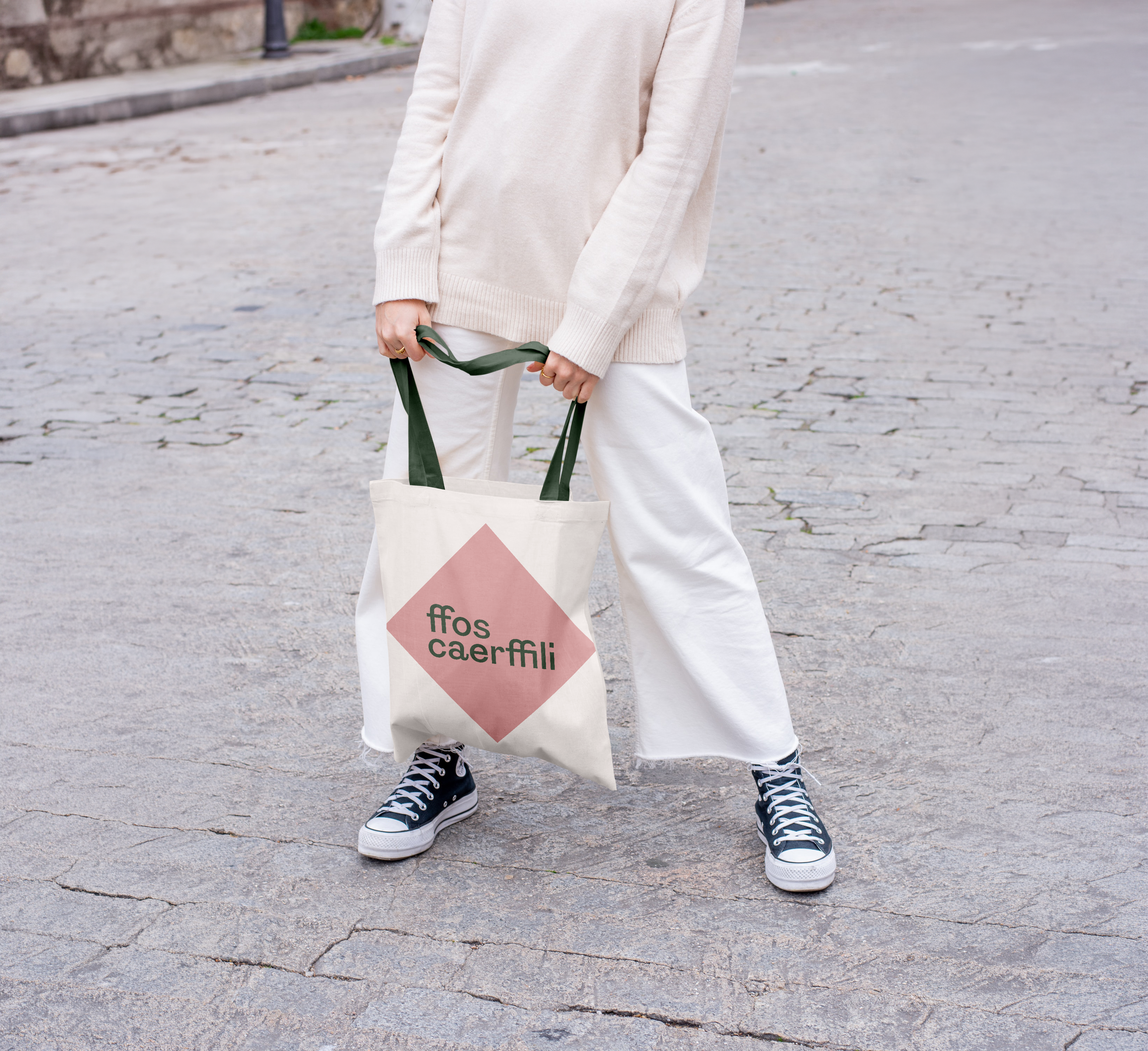 Woman holding tote bag with the Ffos Caerffili logo on it